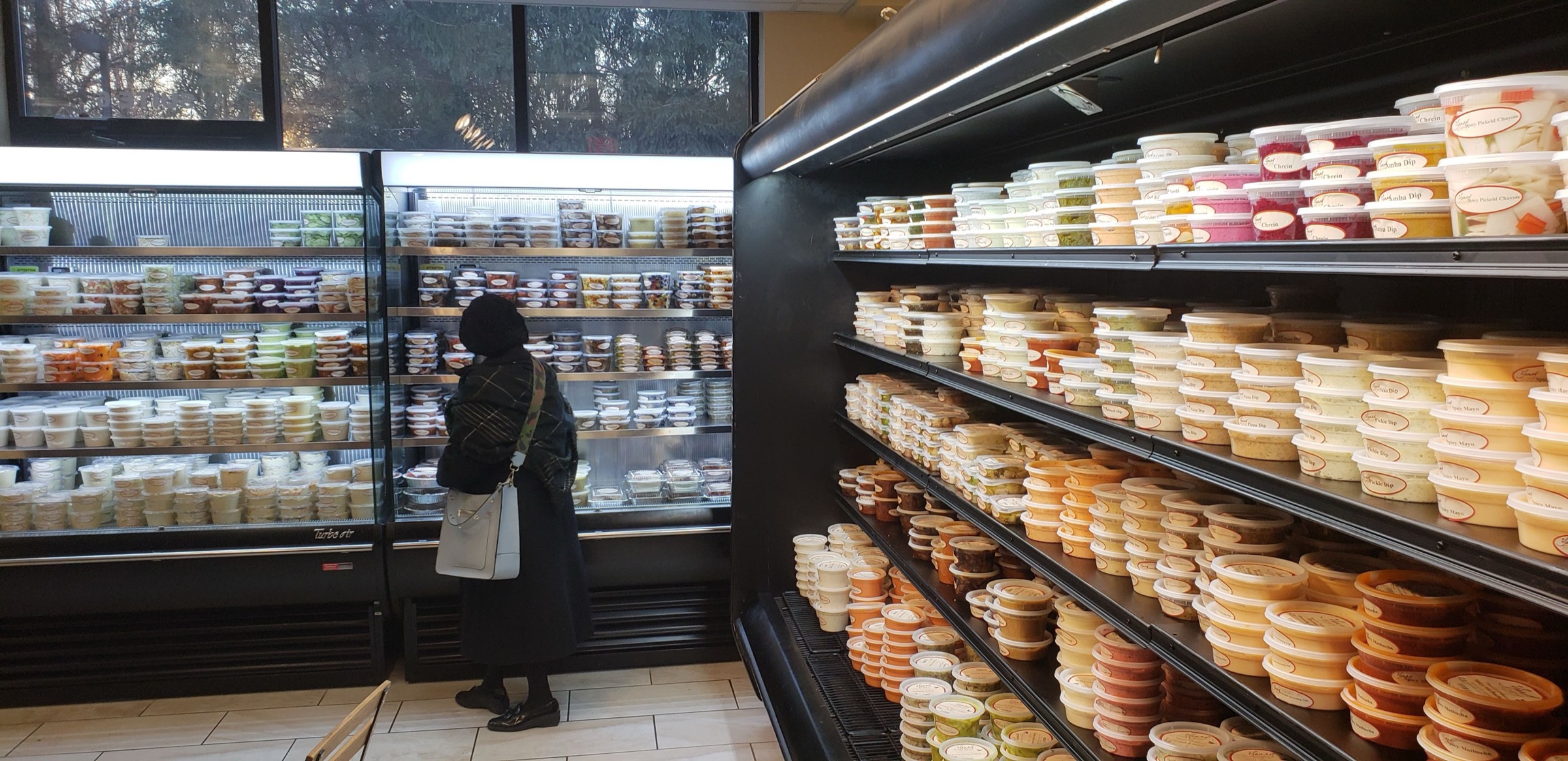 Rows of Yanay dips and salads in the shop's refrigerated cases
